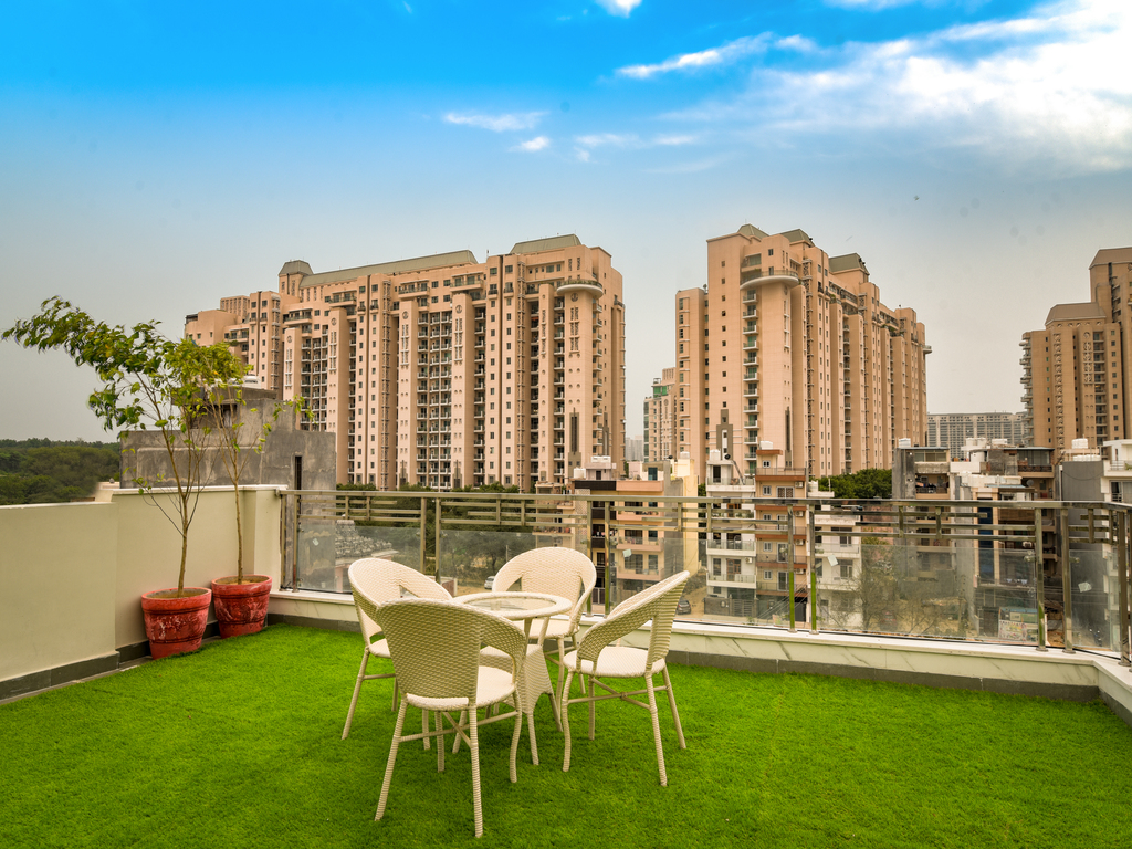 A mesmerizing Aravali hills view from the rooftop sitting in lust green garden