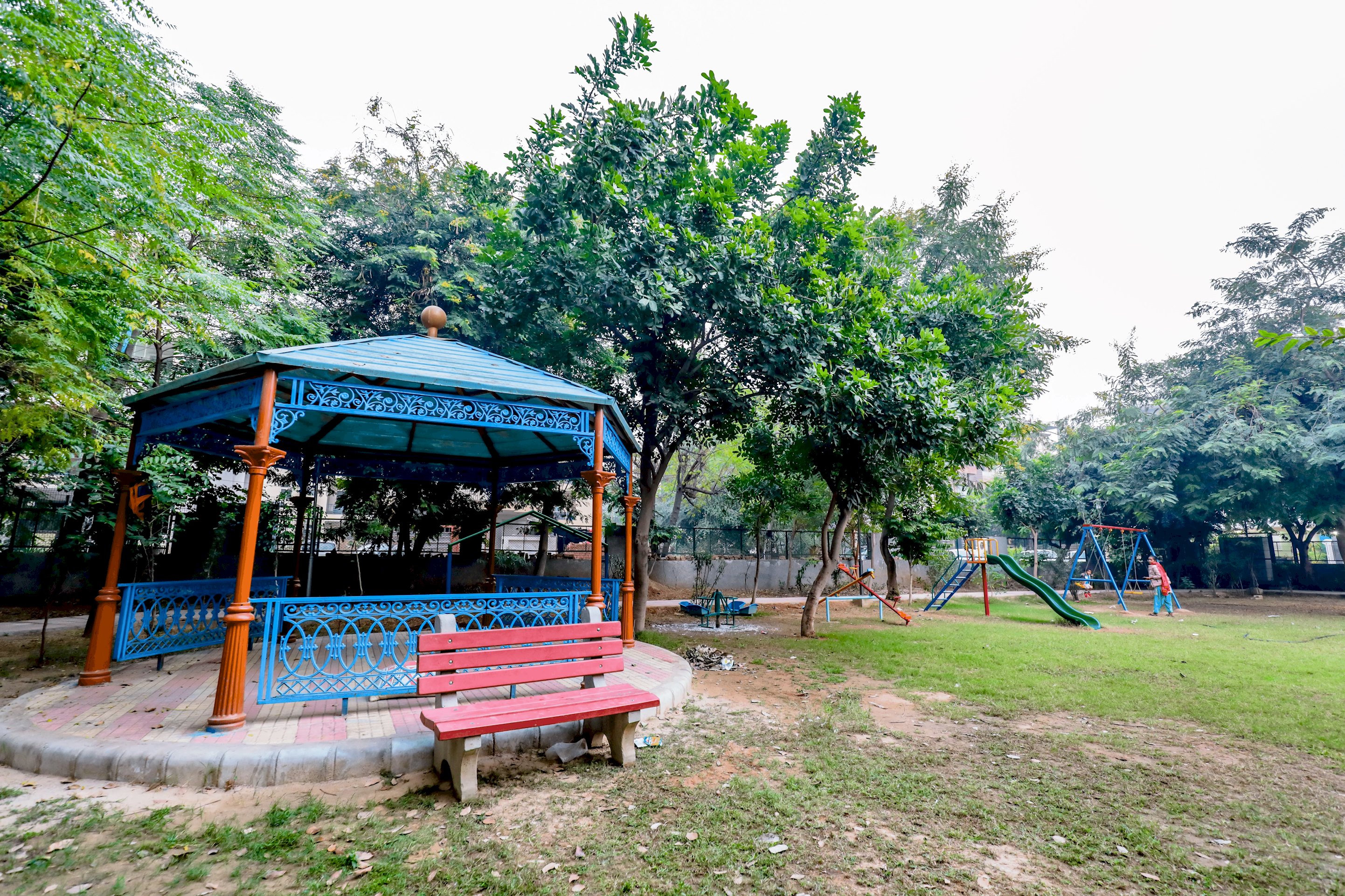 Lively Park Ambience: Children Delight in Rides and Games, Surrounded by Vibrant Play Equipment, While Echoes of Joyful Laughter Fill the Air.
