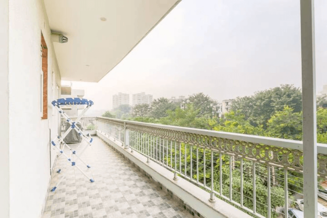 A serene oasis: A sun-kissed balcony adorned with lush green plants and comfortable seating, offering a peaceful retreat amidst the urban hustle and bustle.